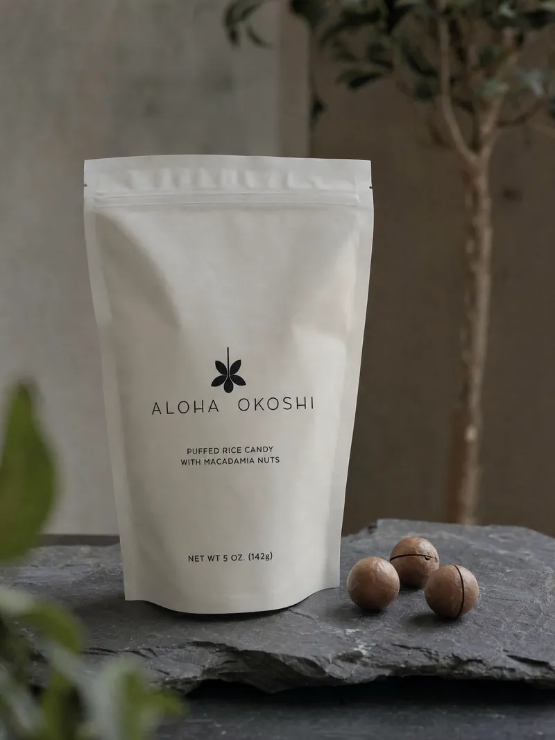 The bag on dark slate beside three macadamia nuts in their shells