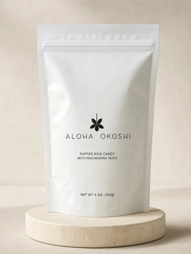 The Aloha Okoshi bag on a pale stone plinth against a soft cream backdrop