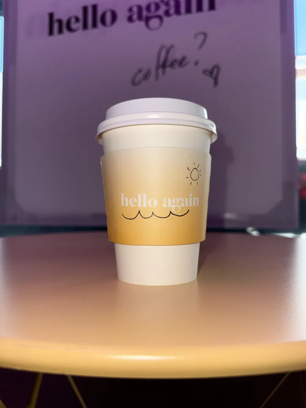 The phone photo: a Hello Again cup on a cafe table